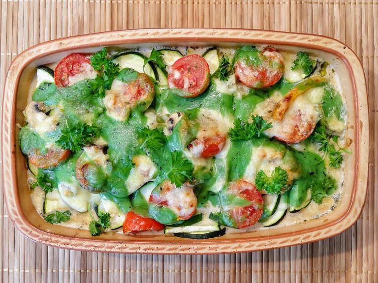 Un gratin de courgettes avec des tomates et des herbes aromatiques au-dessus