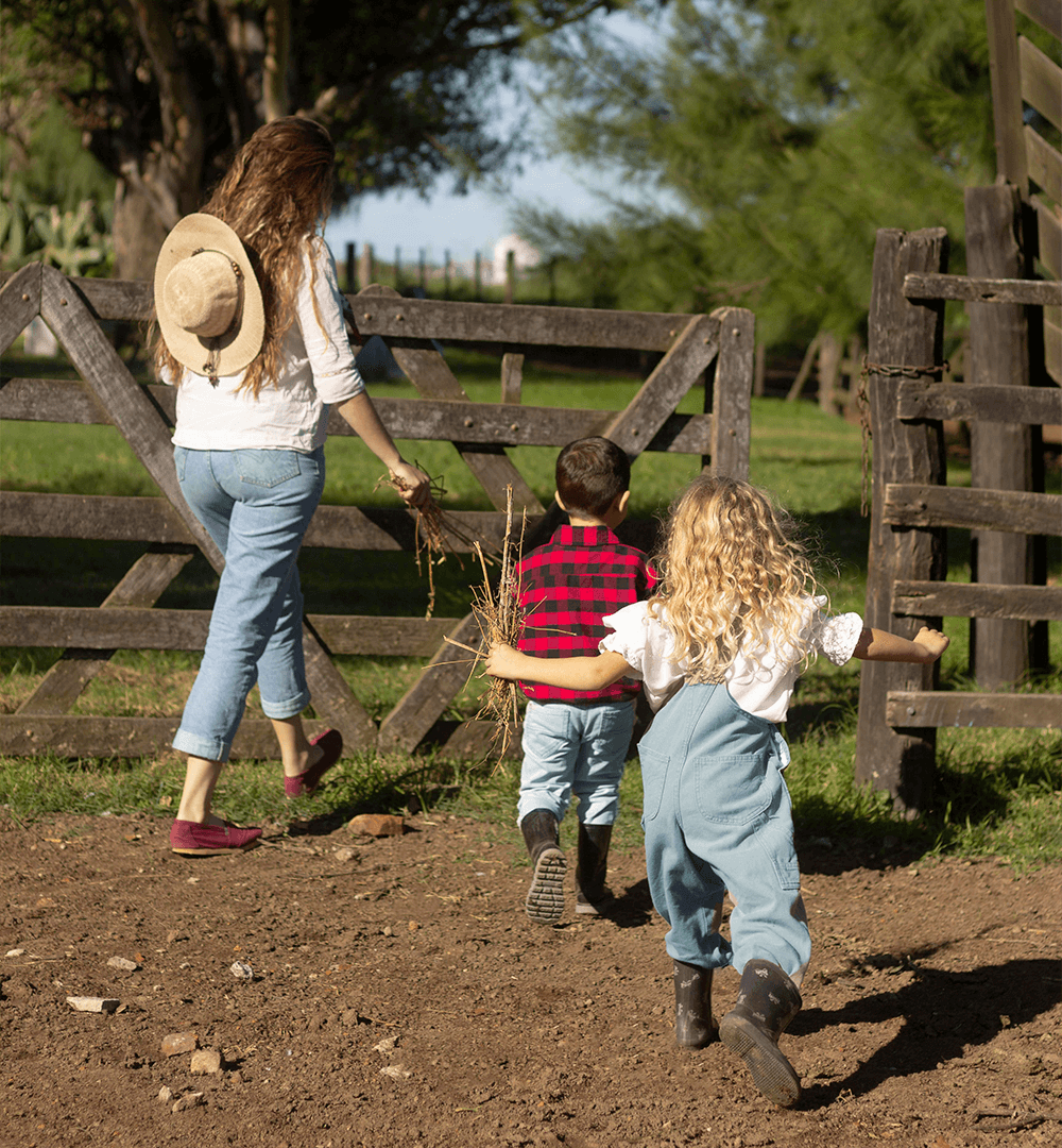 Femme et deux enfants entrant dans un pré