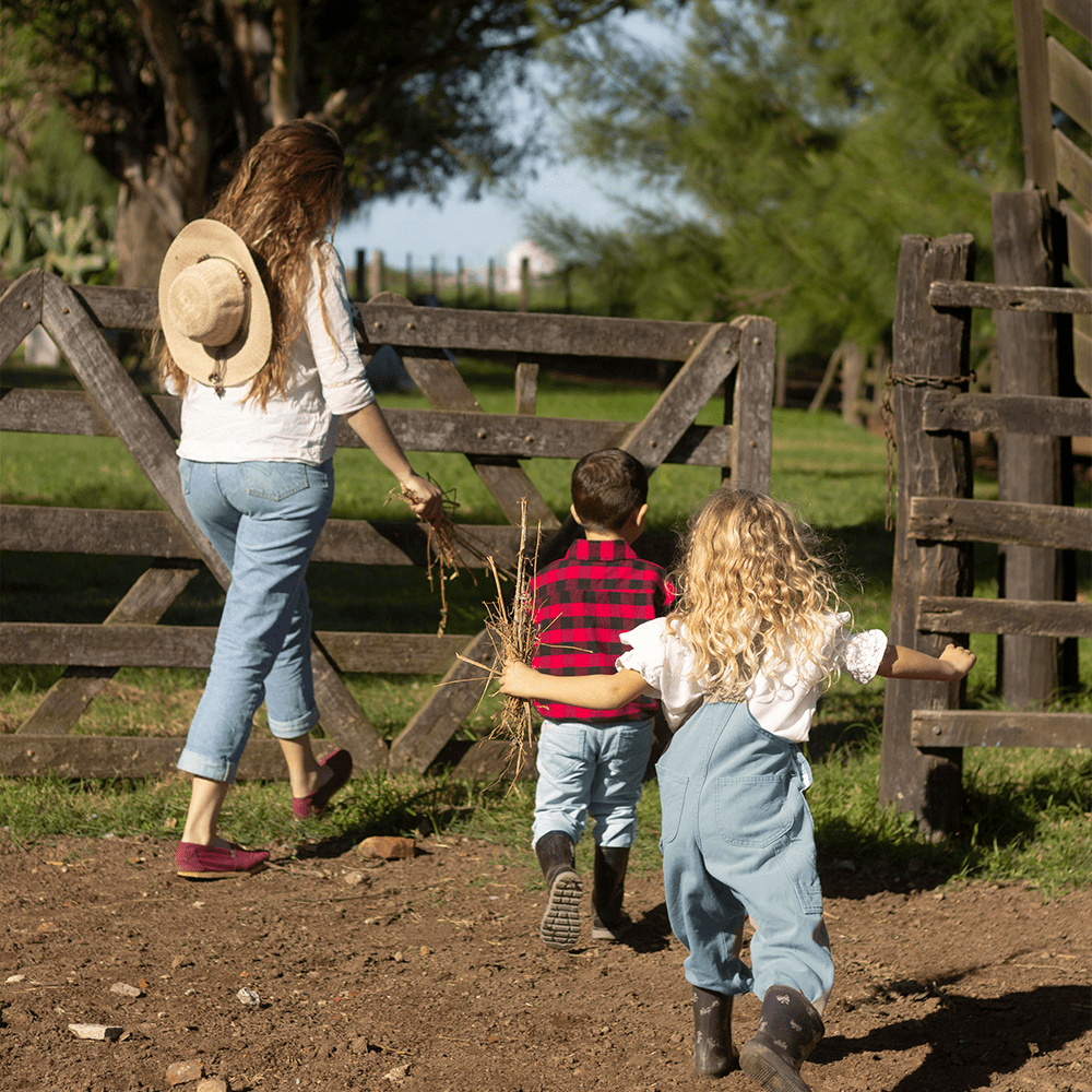 Femme et deux enfants entrant dans un pré
